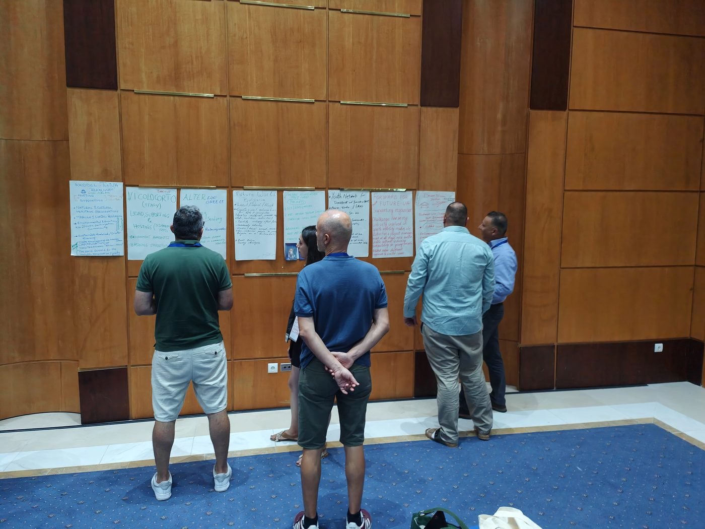 Participants reading the wall of green challenges posted by each organisation