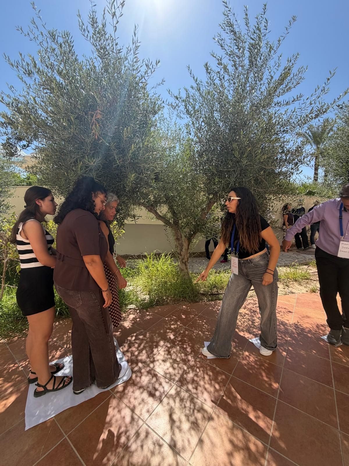 Participants talking between sessions under the olive trees in Djerba